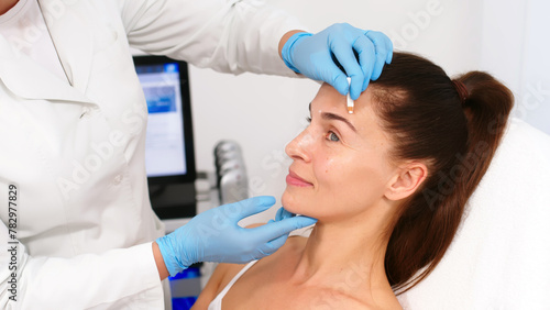 Close-up. Before the procedure for facial contouring or plastic surgery, the cosmetologist makes markings on the patient’s face. Time to prepare for a cosmetic procedure.
