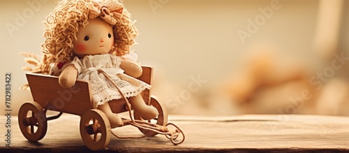 Small ragdoll in wooden wagon on table photo
