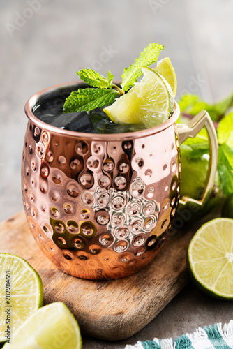 Photography Moscow mule cocktail served with ice and slice of lime on wooden table