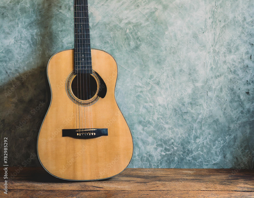 Naklejka premium Acoustic guitar resting against a blank grunge background with copy space