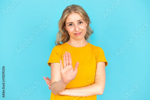 Young woman making hand stop sign, showing disagreement gesture