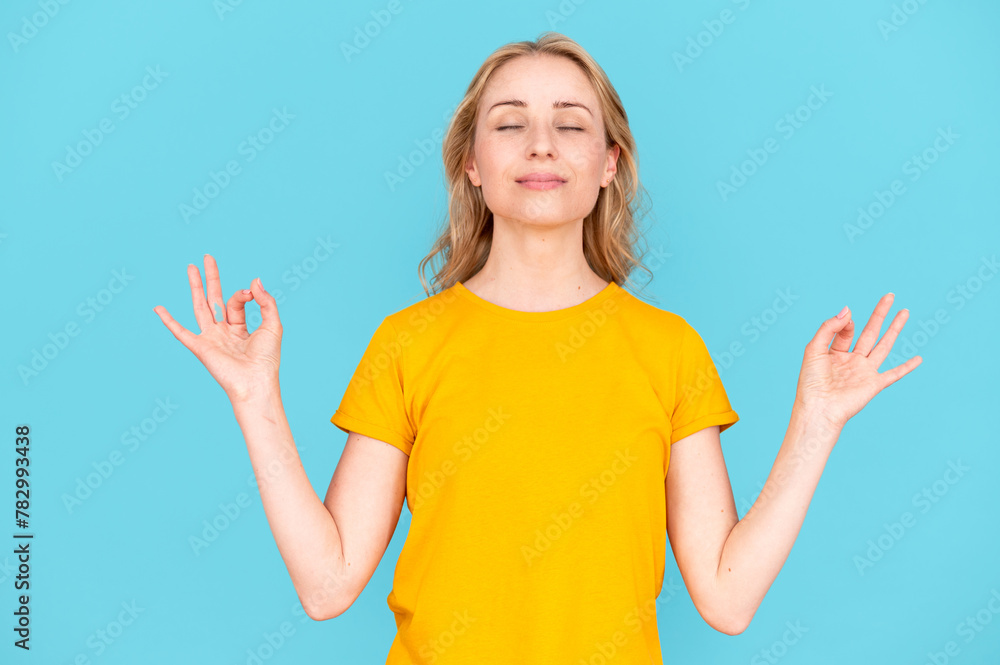 Young calm woman with closed eyes hold hands in mudra gesture - obrazy, fototapety, plakaty 