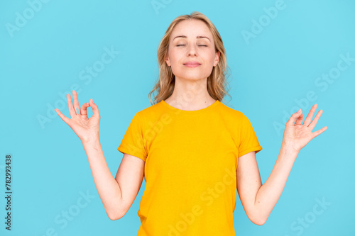 Young calm woman with closed eyes hold hands in mudra gesture
