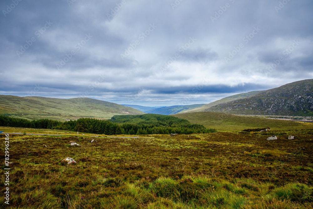 Idyllic view in Glendalough Valley, County Wicklow, Ireland. Mountains, lake and tourists walking paths