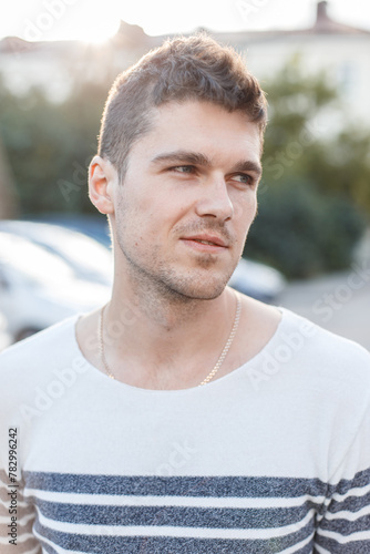 Male street portrait of a handsome successful guy at sunset