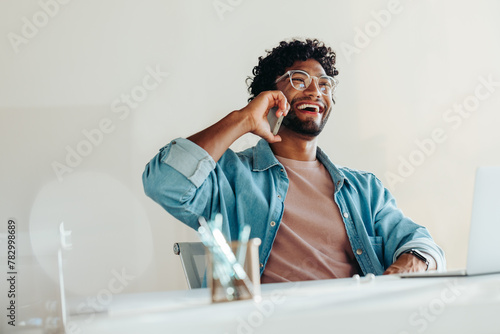 Successful businessman using a smartphone for a phone call conversation in an office