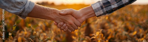 Two people shaking hands over a fresh crop field photo