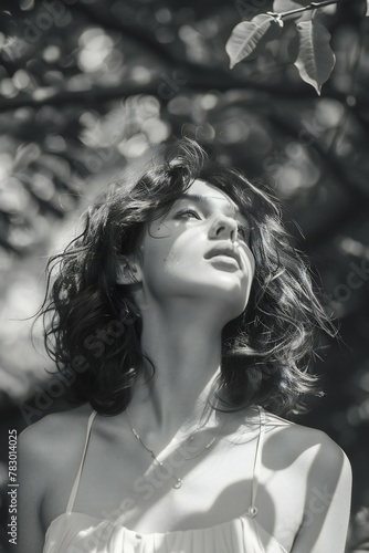 Beautiful brunette woman in the garden, black and white photo