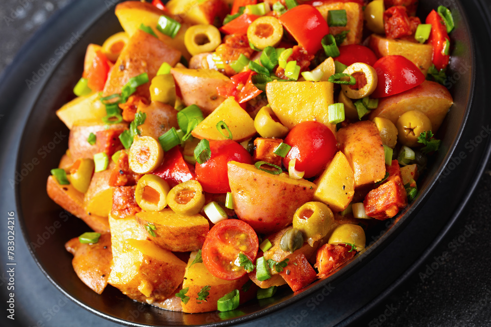 spanish potato salad with chorizo in black bowl spanish potato salad with chorizo in black bowl