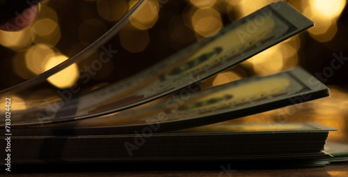 Flipping through stack of 100 US dollars bills, Counting cash and bend curve dollar bills with dream gold bokeh background. Dollar bills filling counting currency money cash