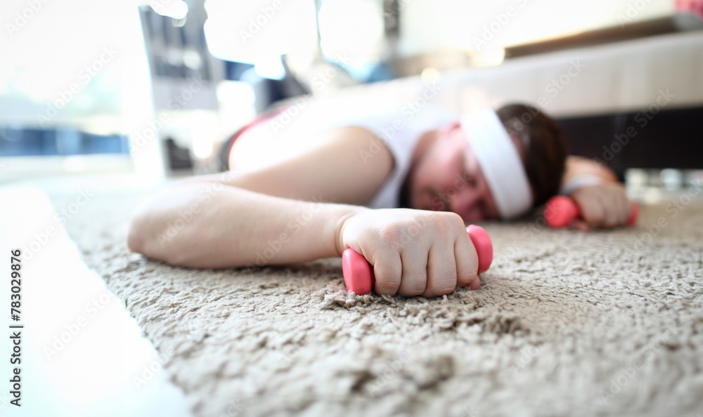 Exhausted Man Sleep and Hold Dumbbells in Hands. Young Male Tired by Fitness Training Lying on Floor in Apartment. Guy with Sports Equipment. Overweight Guy Practice Aerobic for Weight Loss Exhausted Man Sleep and Hold Dumbbells in Hands. Young Male Tired by Fitness Training Lying on Floor in Apartment. Guy with Sports Equipment. Overweight Guy Practice Aerobic for Weight Loss