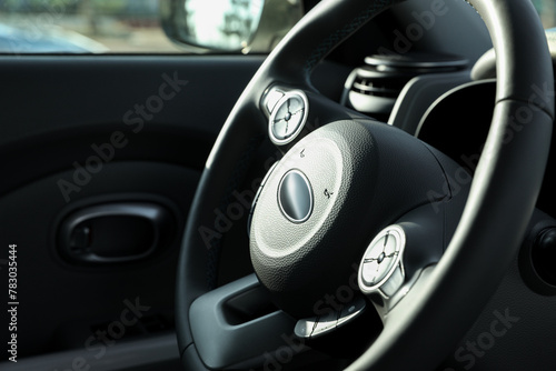 Black steering wheel inside of modern car, closeup © New Africa