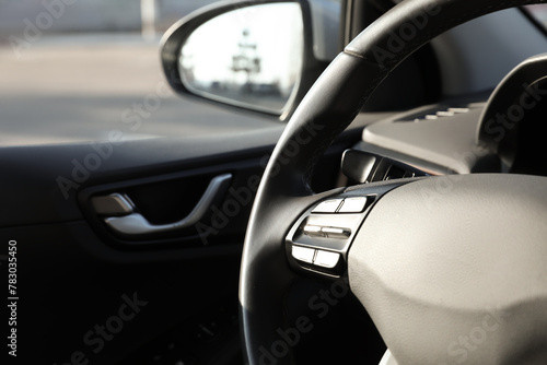 Black steering wheel inside of modern car, closeup. Space for text