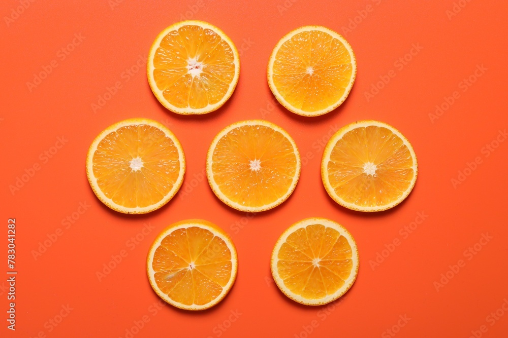 Slices of juicy orange on terracotta background, flat lay Slices of juicy orange on terracotta background, flat lay