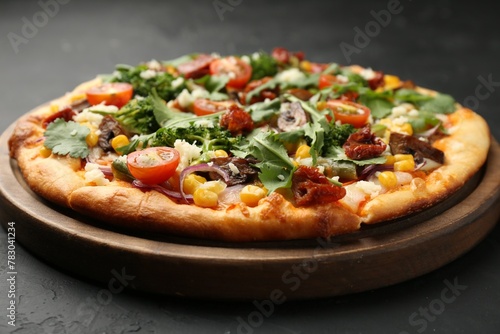 Delicious vegetarian pizza with cheese, mushrooms, vegetables and greens on black table, closeup