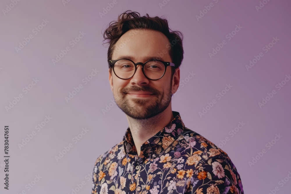Portrait of a handsome young man in glasses and a floral shirt on a purple background Portrait of a handsome young man in glasses and a floral shirt on a purple background