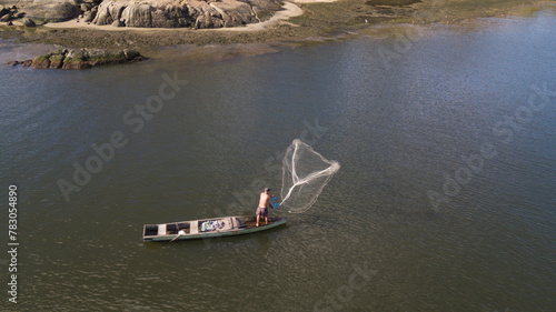 Pescador joga tarrafa no canal de Camburi, em vitória, Espírito Santo, Brasil.