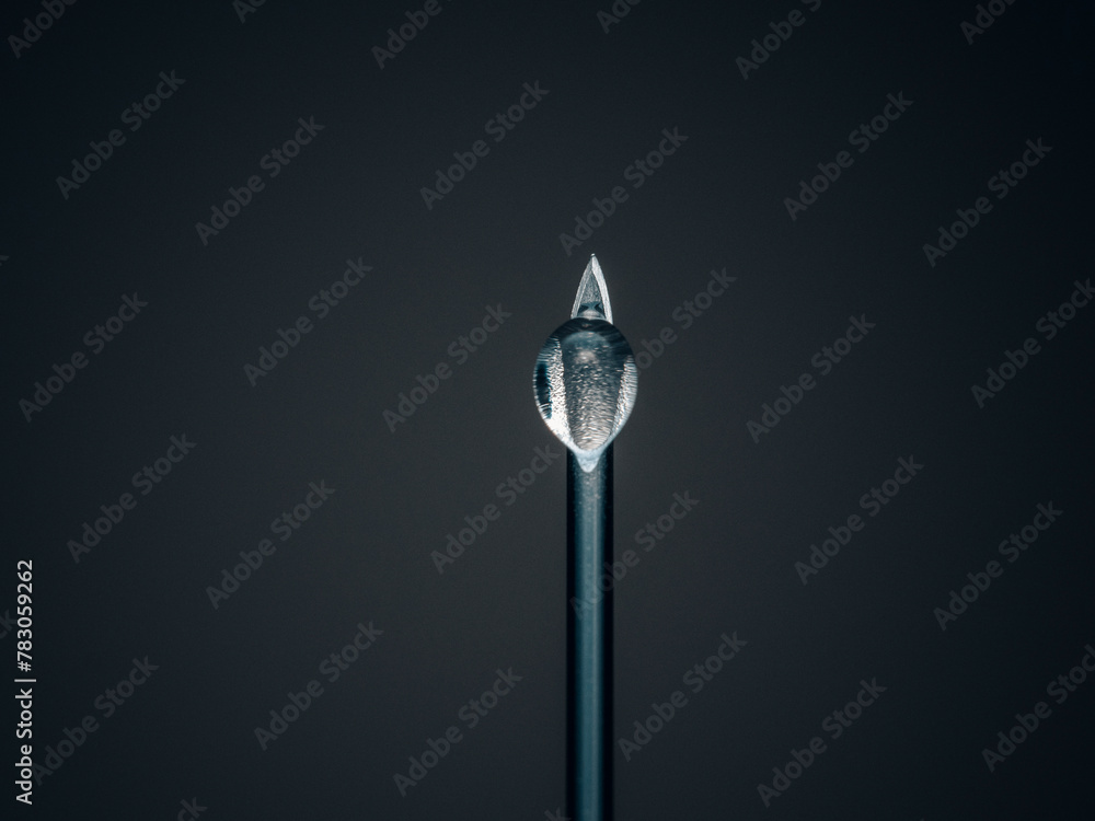 vertical shot of black needle with drop vertical shot of black needle with drop