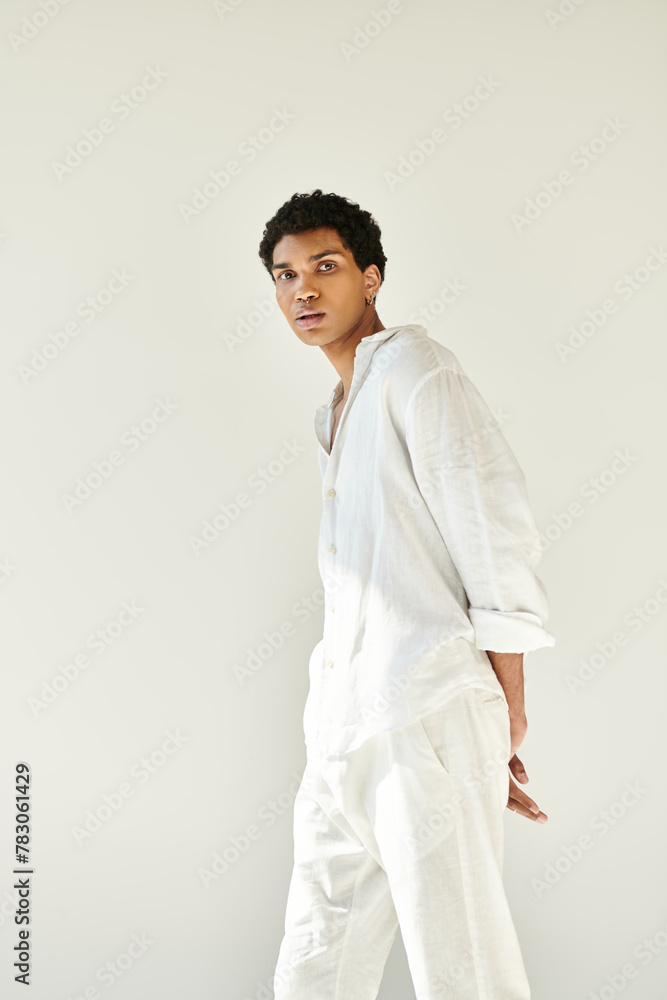 elegant appealing african american man in cozy outfit posing on beige backdrop and looking at camera elegant appealing african american man in cozy outfit posing on beige backdrop and looking at camera