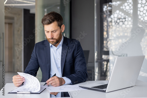 Φωτογραφία Serious young man businessman, company owner and executive director working at d