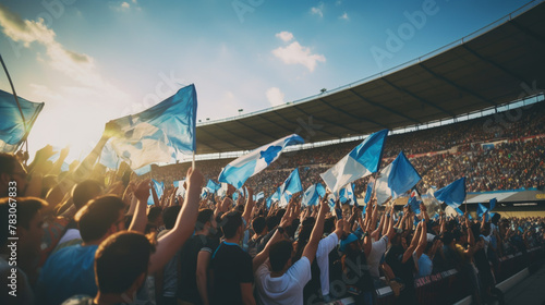 group of fans dressed in blue color watching a sports event in the stands of a stadium photo