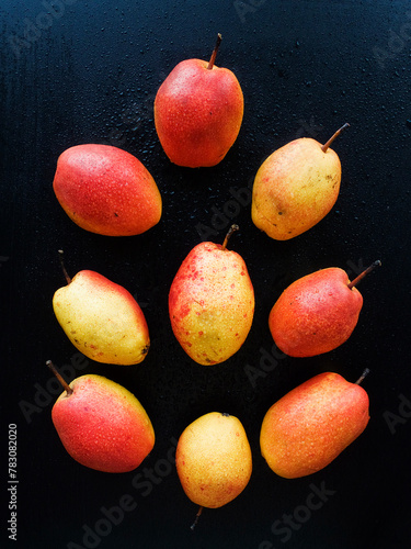 Fresh ripe pears laying on the black background. Top view.
