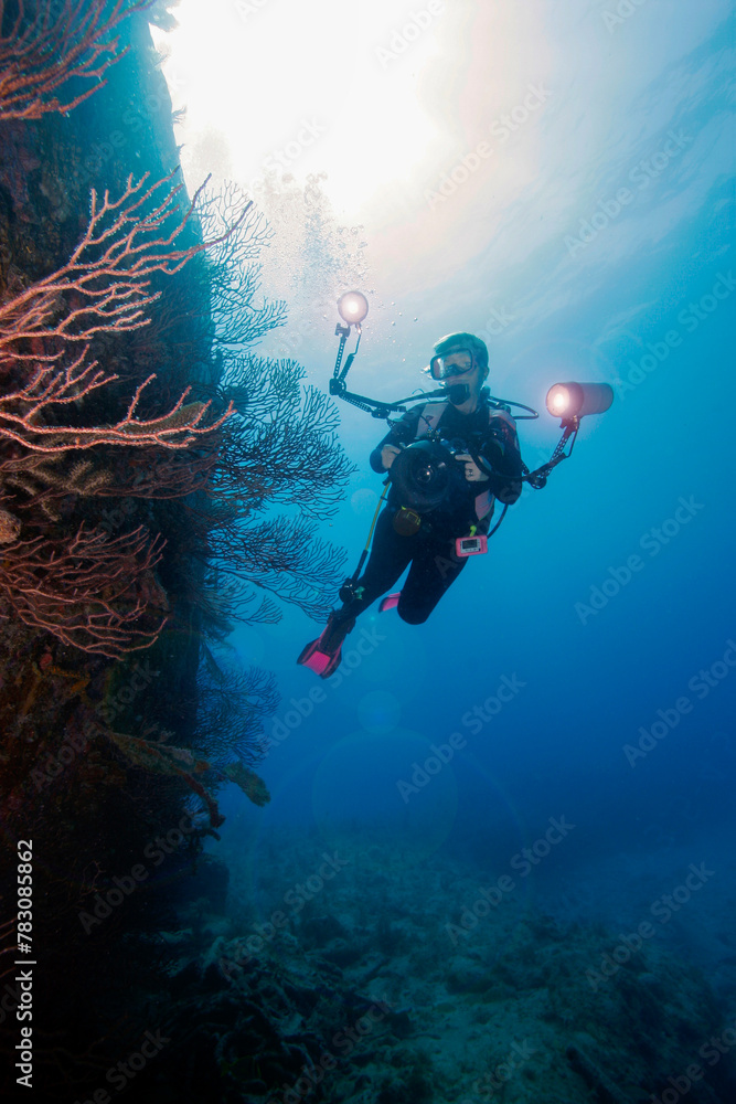 An underwater photographer exploring the WWII wreck of the Benwood off Key Largo in the Florida Keys An underwater photographer exploring the WWII wreck of the Benwood off Key Largo in the Florida Keys