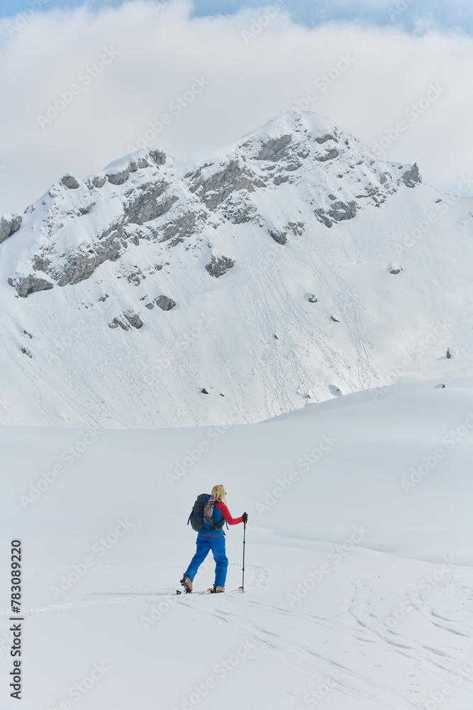 A professional woman skier rejoices after successfully climbing the snowy peaks of the Alps