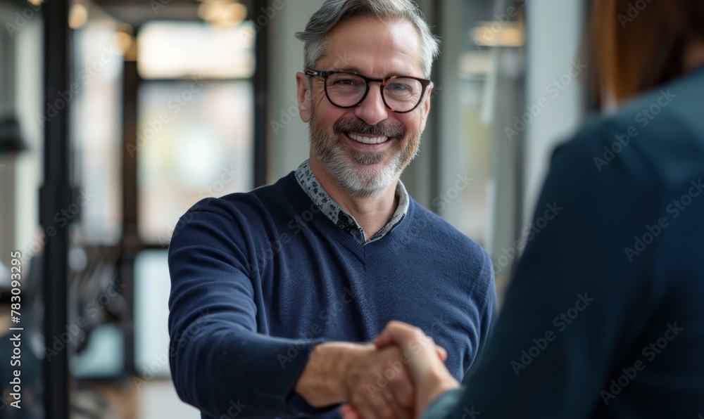 Man with glasses smiling, shaking hands at vision care event Man with glasses smiling, shaking hands at vision care event