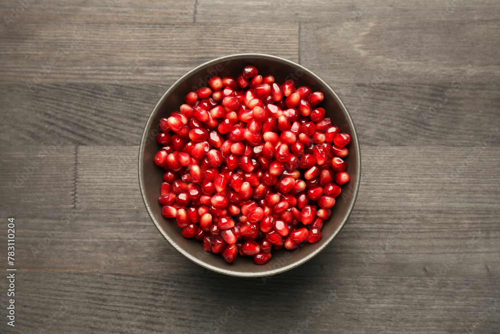 Tasty ripe pomegranate grains on dark wooden table, top view Tasty ripe pomegranate grains on dark wooden table, top view