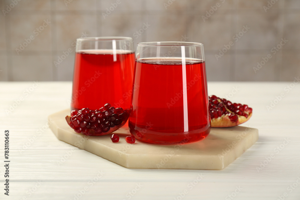Tasty pomegranate juice in glasses and fresh fruit on white wooden table - obrazy, fototapety, plakaty 