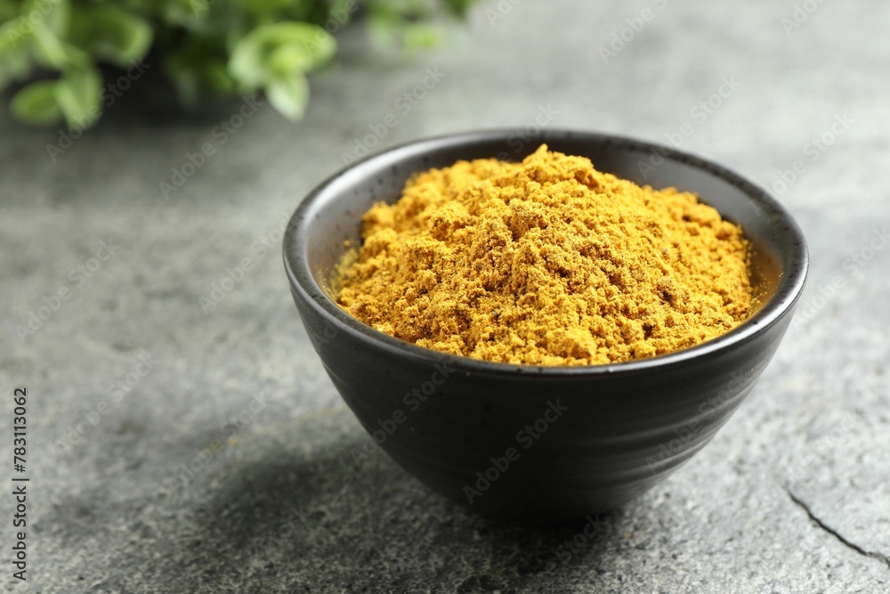 Dry curry powder in bowl on dark textured table, closeup Dry curry powder in bowl on dark textured table, closeup