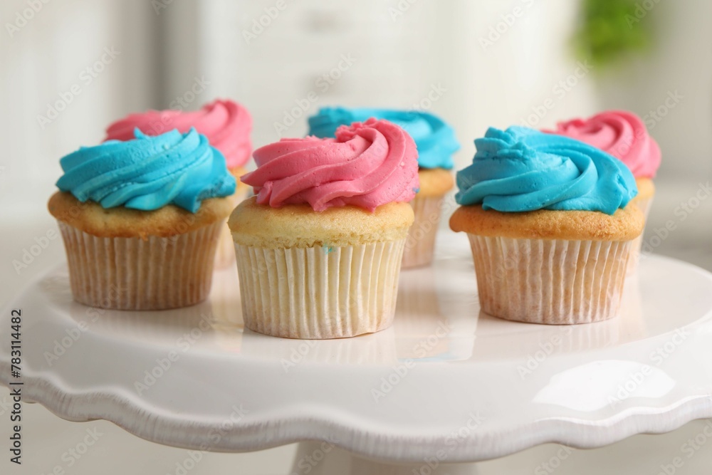 Delicious cupcakes with bright cream on dessert stand indoors, closeup