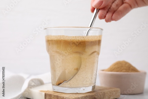 Dietary fiber. Woman stirring psyllium husk powder in water at table, closeup