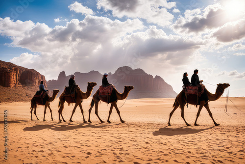 A group of camels  chairs ready for tourists  walking in the desert on a sunny afternoon and people on horseback against the backdrop of sandstone formations 