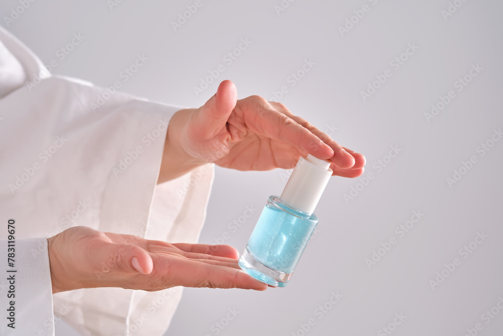Blue serum with pipette in a womans hands in a robe. Blue serum with pipette in a womans hands in a robe.