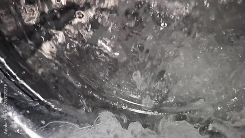 super slow-motion of water splashing in a washing machine, heavy interpolation artifacts in video made with a cellphone