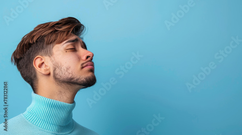 A man with a beard and a blue sweater is looking at the camera