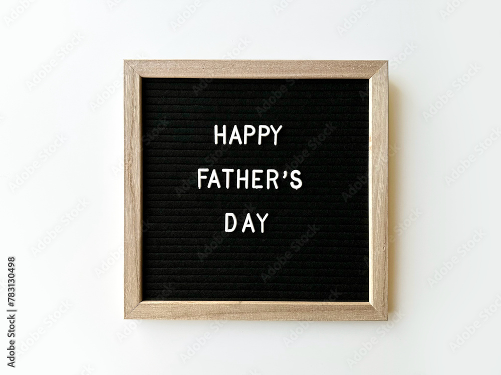 Happy Father's day spelled on the black letter board with white letters, isolated on white background.
