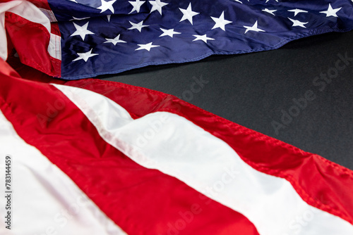 American flag on the folded to the left side of  background of black texture 