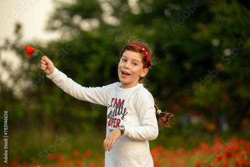 Bambina con capelli rossi e coroncona rossa, in mezzo ai papaveri