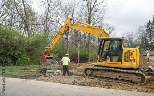 Backhoe Delivering Cement for Catch Basin