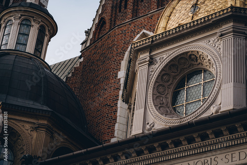 Round window with golden lattice, architectural details of Wawel Royal Castle, Krakow, Poland