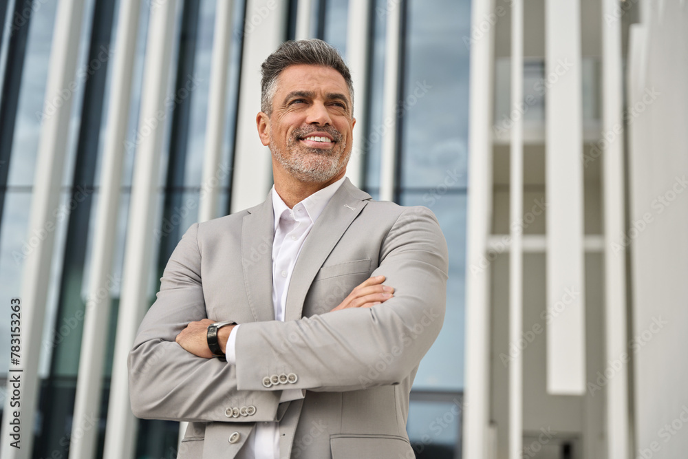 Happy older businessman ceo, confident middle aged business man leader, senior company executive, mature investor wearing suit standing arms crossed looking away thinking or future dream success. Happy older businessman ceo, confident middle aged business man leader, senior company executive, mature investor wearing suit standing arms crossed looking away thinking or future dream success.