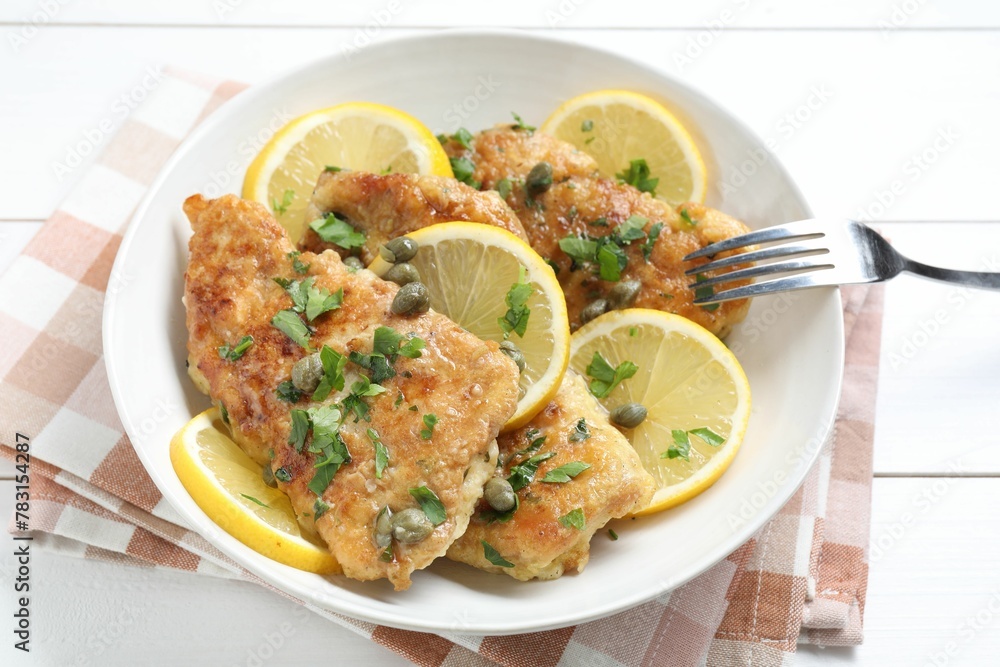 Delicious chicken piccata served on white wooden table Delicious chicken piccata served on white wooden table