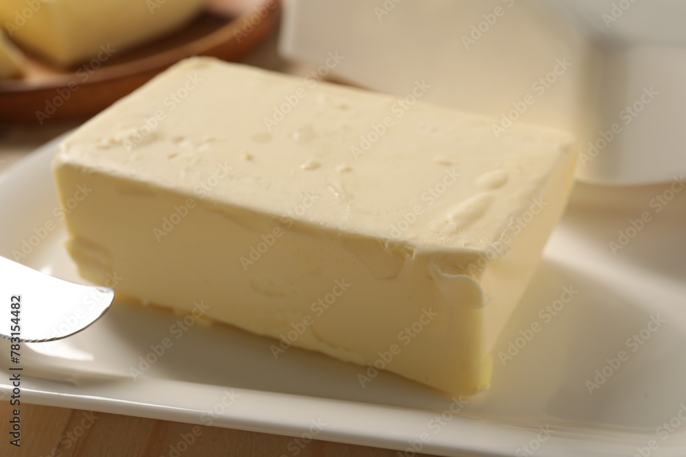 Block of tasty butter on plate, closeup
