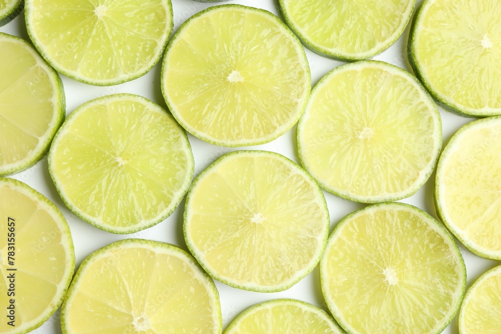 Fresh juicy lime slices on white background, flat lay Fresh juicy lime slices on white background, flat lay