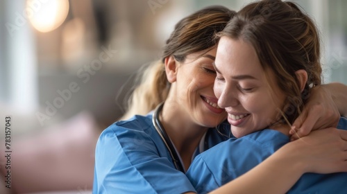 Two female healthcare workers wearing scrubs are embracing each other in a warm hug. The gesture conveys care, compassion, and support between the coworkers. photo