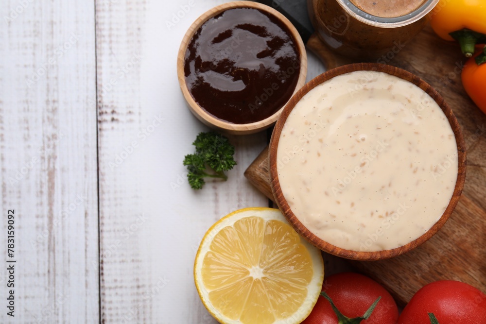 Different fresh marinades and ingredients on white wooden table, flat lay. Space for text Different fresh marinades and ingredients on white wooden table, flat lay. Space for text