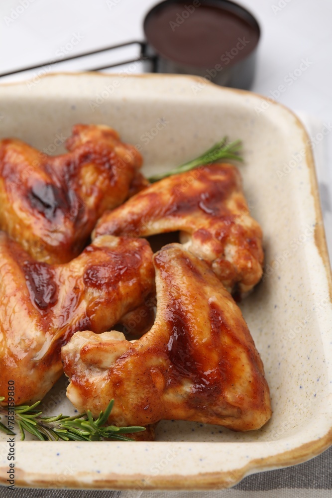 Marinated chicken wings and rosemary on white table, closeup Marinated chicken wings and rosemary on white table, closeup